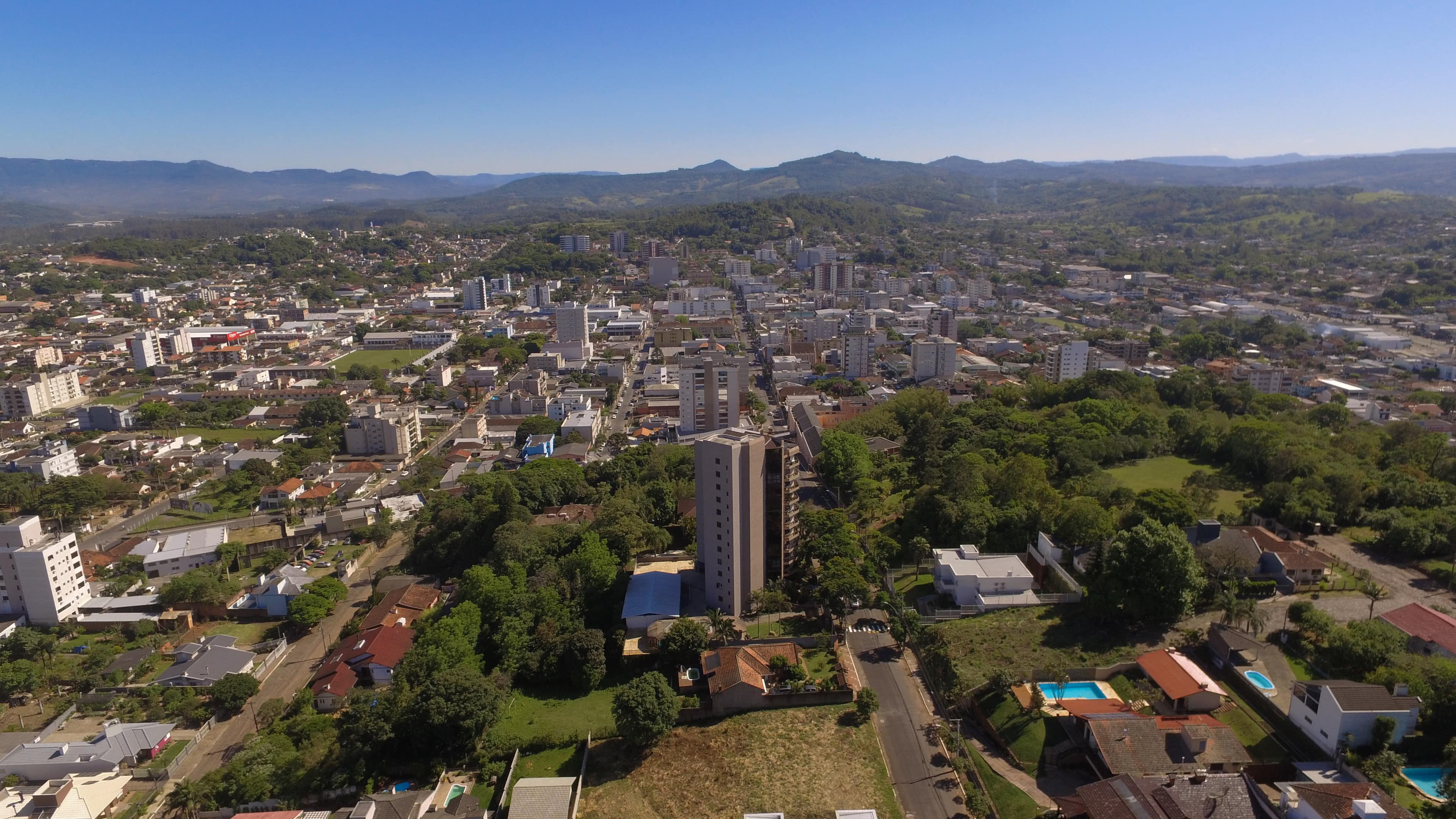 Vista aérea de Taquara, no Vale do Paranhana, com o casario, a mata e os morros ao fundo